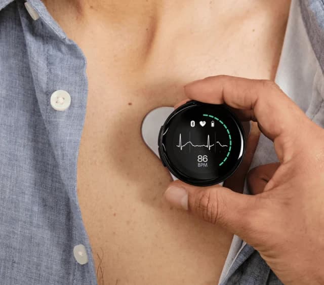 Person holding Sensora heart monitoring device showing heart rate and ECG data